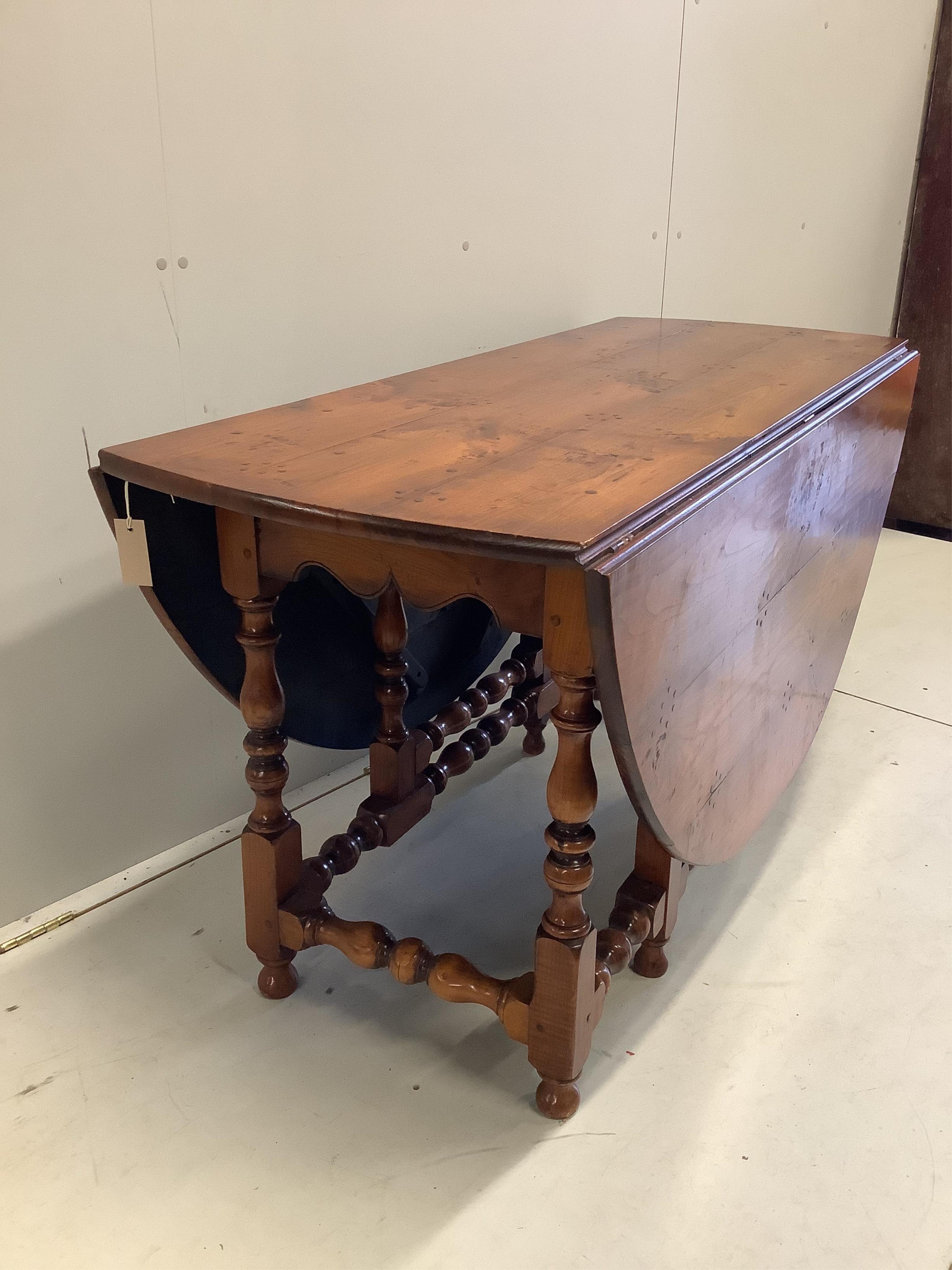 A reproduction 18th century style elm gateleg dining table on turned baluster under frame, width 169cm extended, depth 142cm, height 75cm. Condition - good with a rich colour.